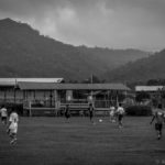 Locals playing soccer on a field next to the school. (Sarawak, Malaysia)