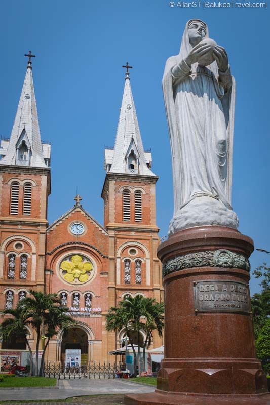 A granite statue of the Virgin Mary stands in front of the Notre Dame Cathedral (Ho Chi Minh City, Vietnam)