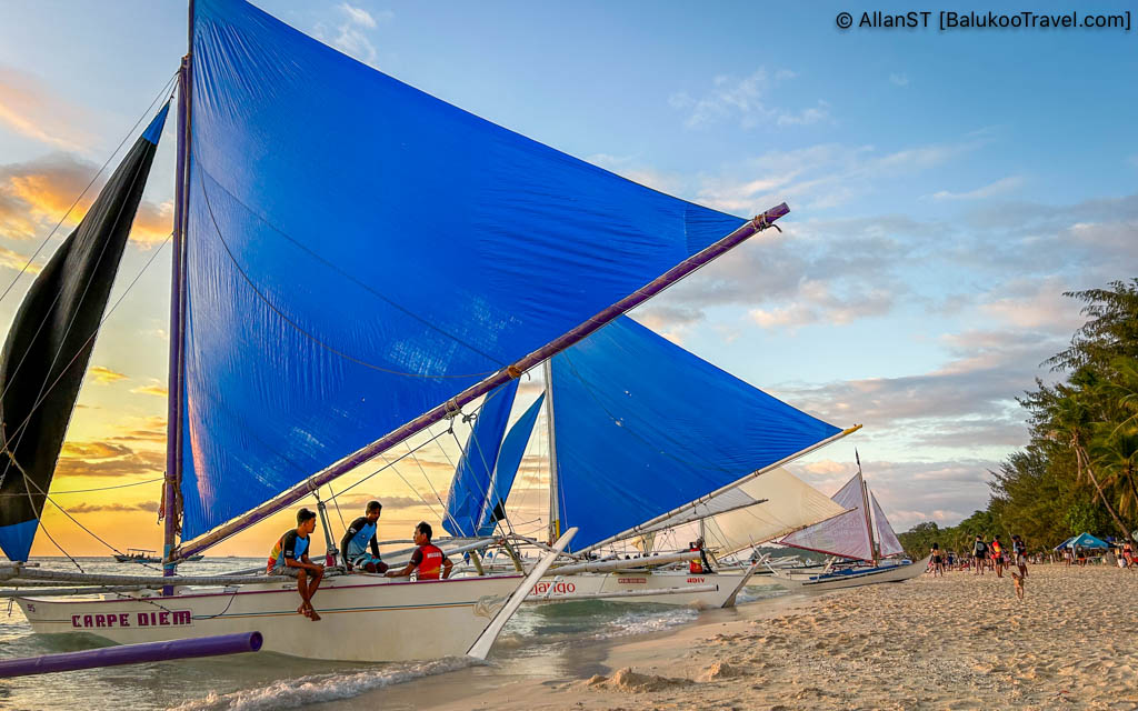 Paraw sail boats lining White Beach during sunset. Boracay 2024