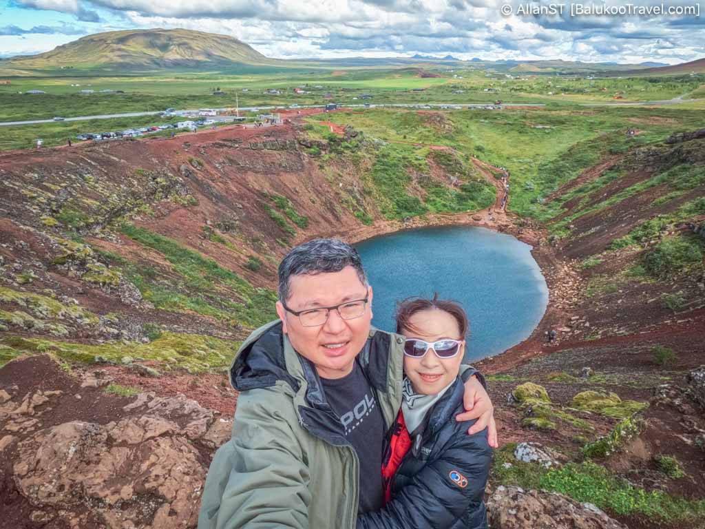 Kerid crater. A volcanic crater with a vivid blue lake surrounded by red and green slopes.